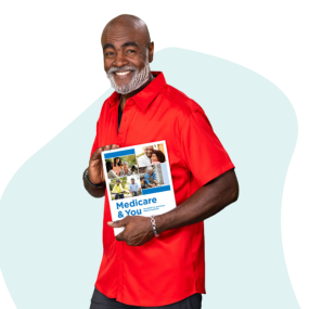 African American man walking, smiling, and holding a copy of the Medicare & You Handbook